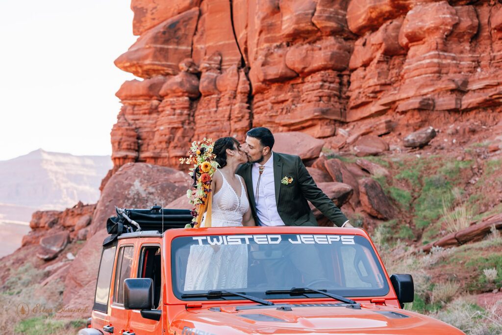 bride and groom kissing in an orange jeep during their adventure elopement in moab