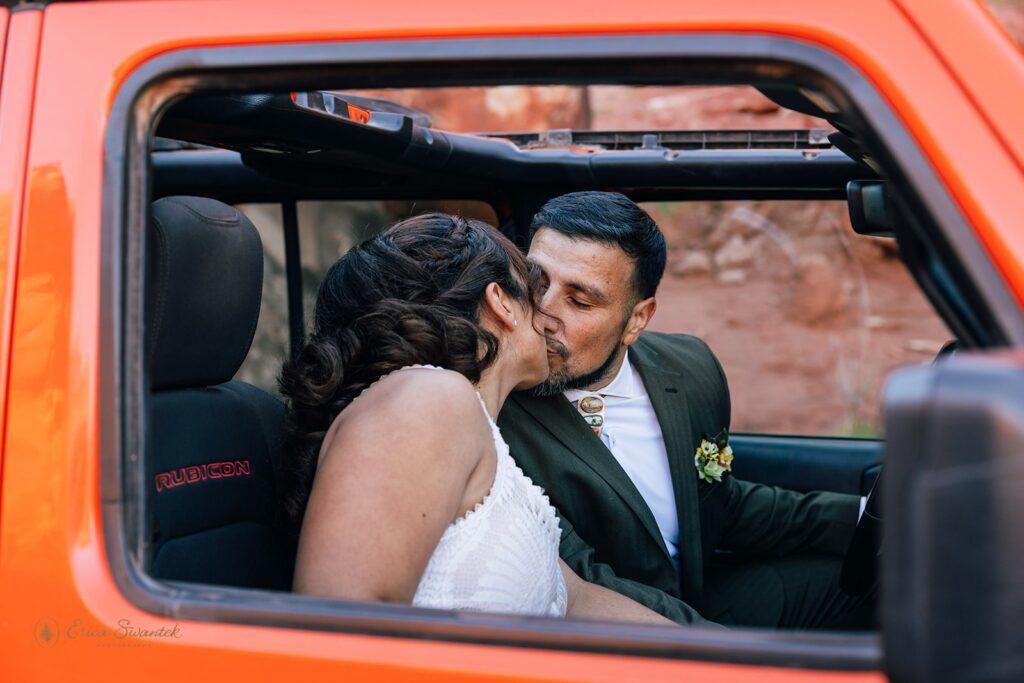 bride and groom kissing in an orange jeep during their adventure elopement in moab