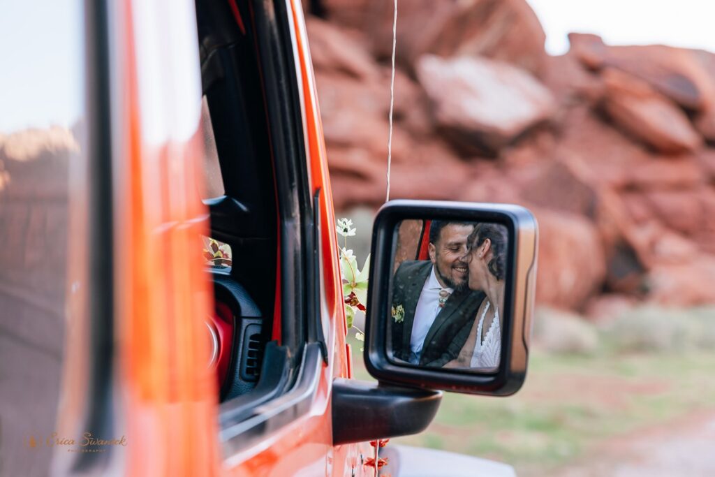 bride and groom kissing in an orange jeep during their adventure elopement in moab