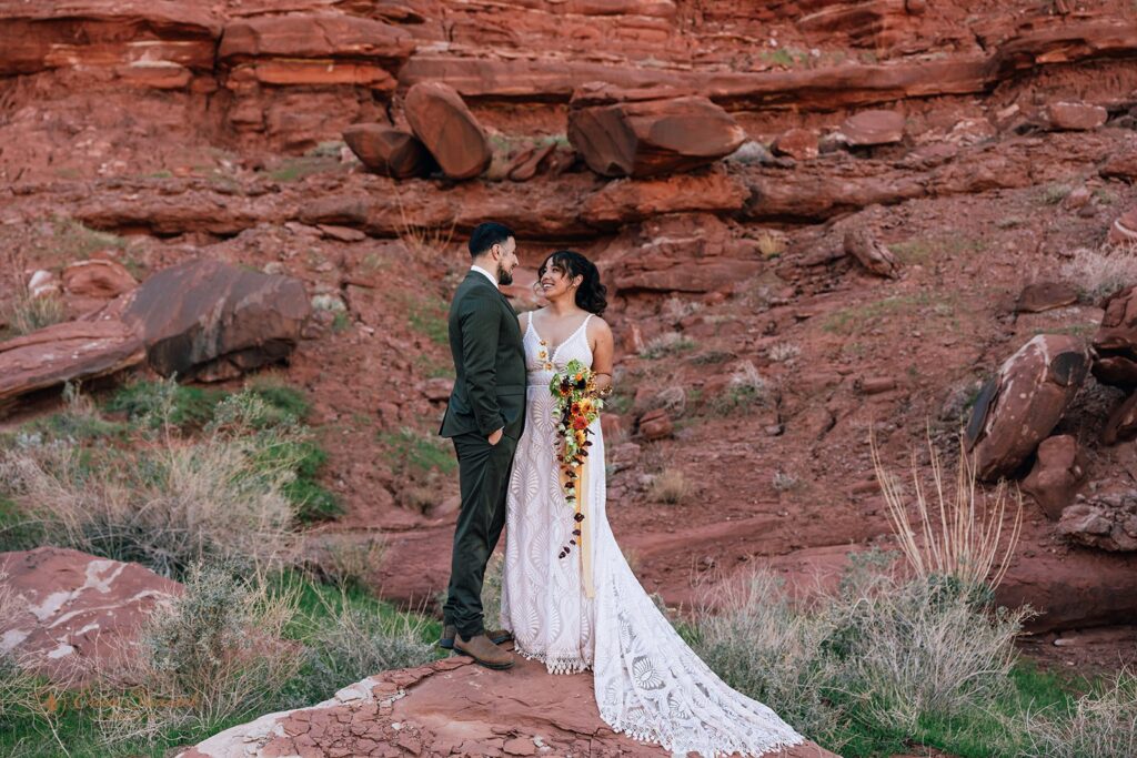 loving bride and groom surrounded by red rock landscapes during their moab elopement