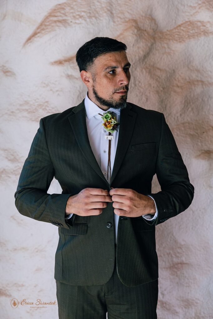 groom putting on a green suit