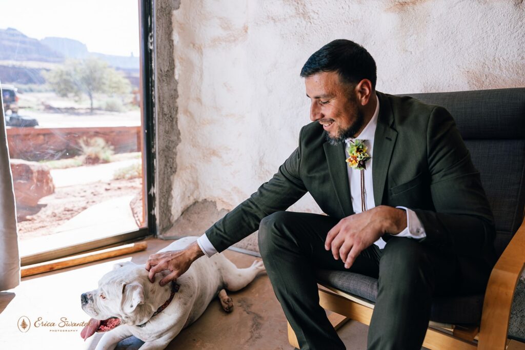 groom getting ready with his dog by his side in a desert airbnb