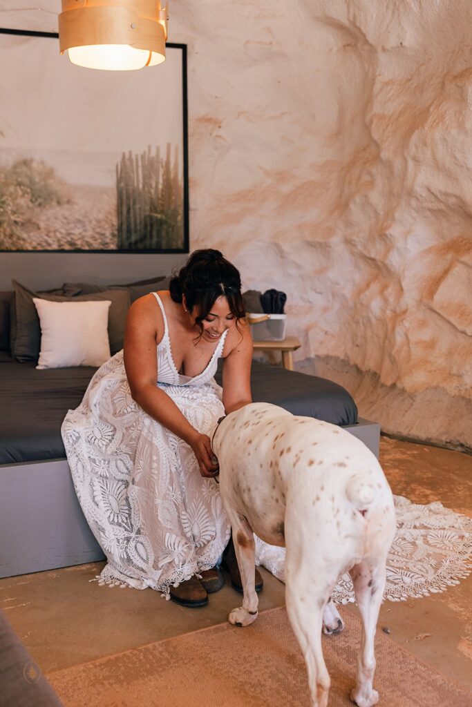 bride getting ready with dog by her side in a desert airbnb