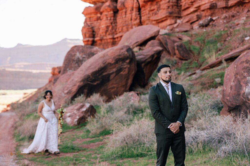candid bride and groom first look in a red rock desert in moab