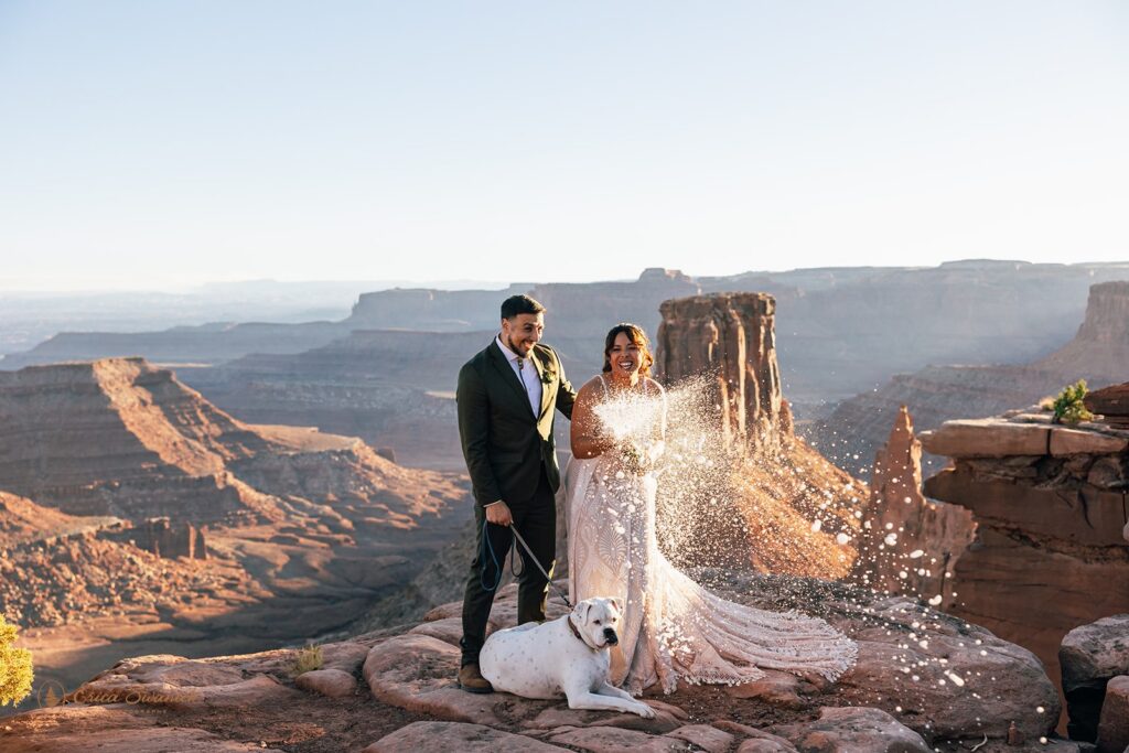 bride and groom popping champagne during their adventurous desert elopement in moab
