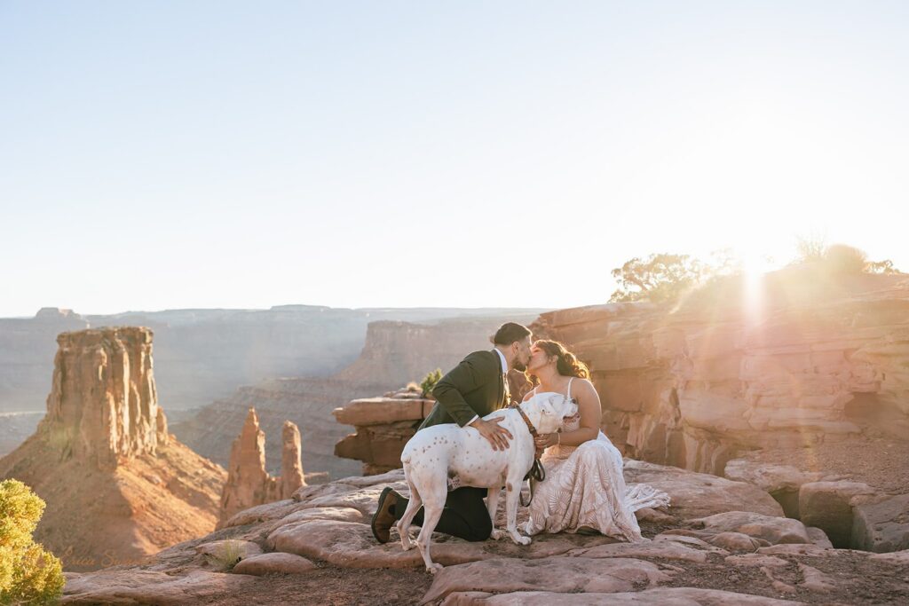 bride and groom with their dog at marlboro point in moab