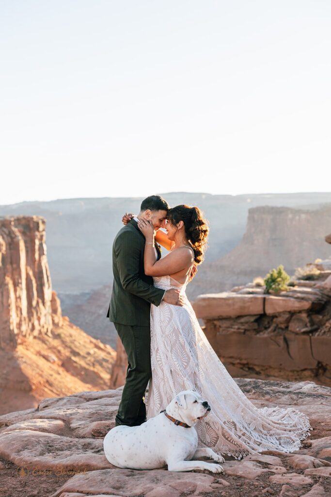 bride and groom with their dog at marlboro point in moab