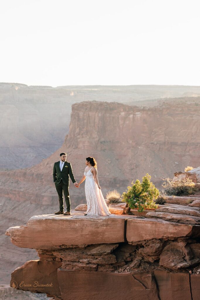 bride and groom surrounded by red rock landscapes at marlboro point in moab