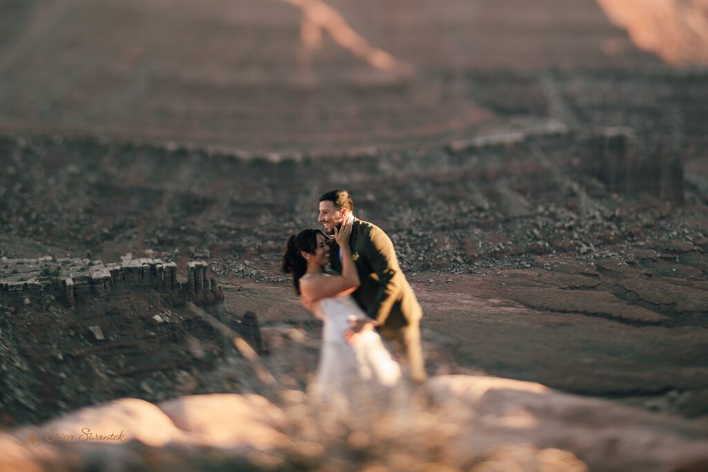 bride and groom surrounded by red rock landscapes at marlboro point in moab