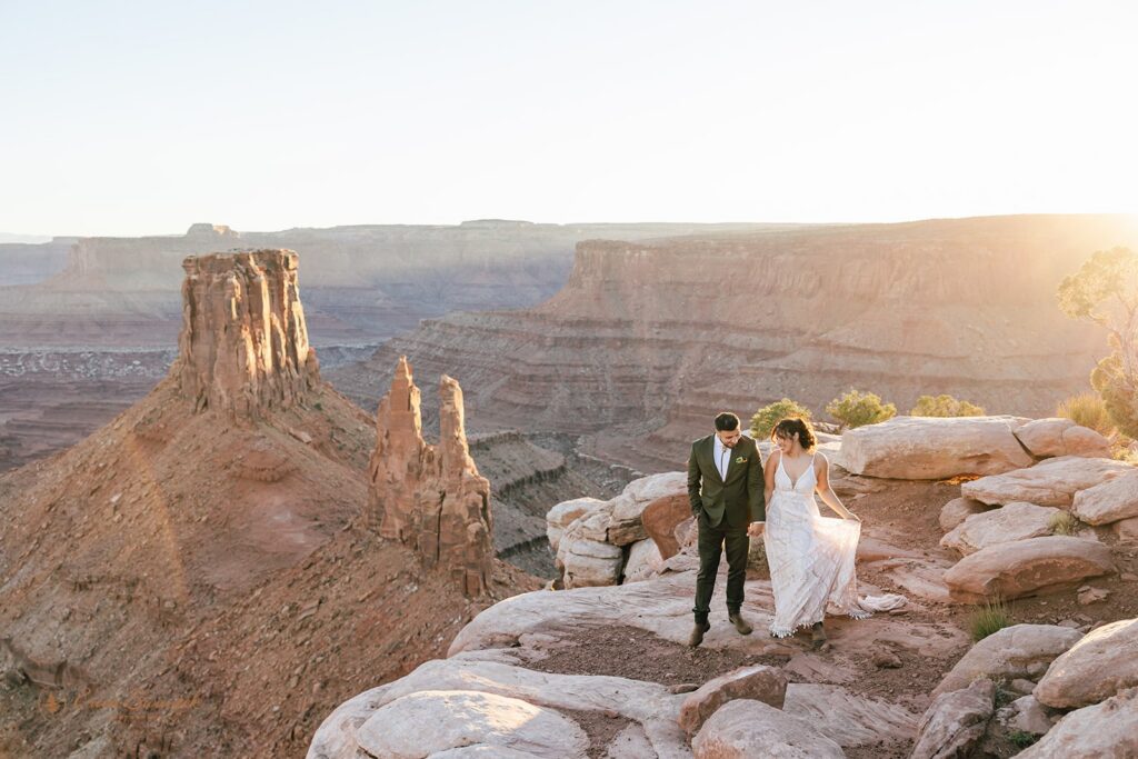 bride and groom surrounded by red rock landscapes at marlboro point in moab