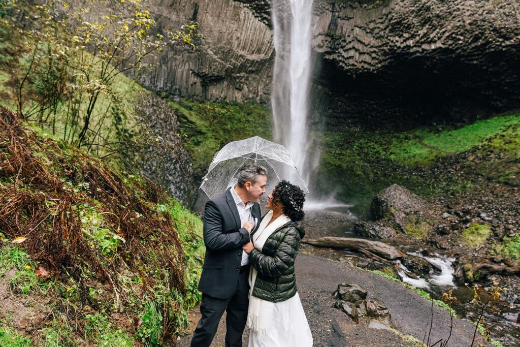 sweet elopement couple in front of a waterfall in pnw