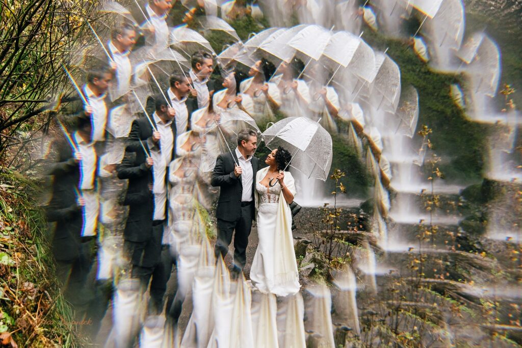 bride and groom hugging in front of a waterfall in pnw
