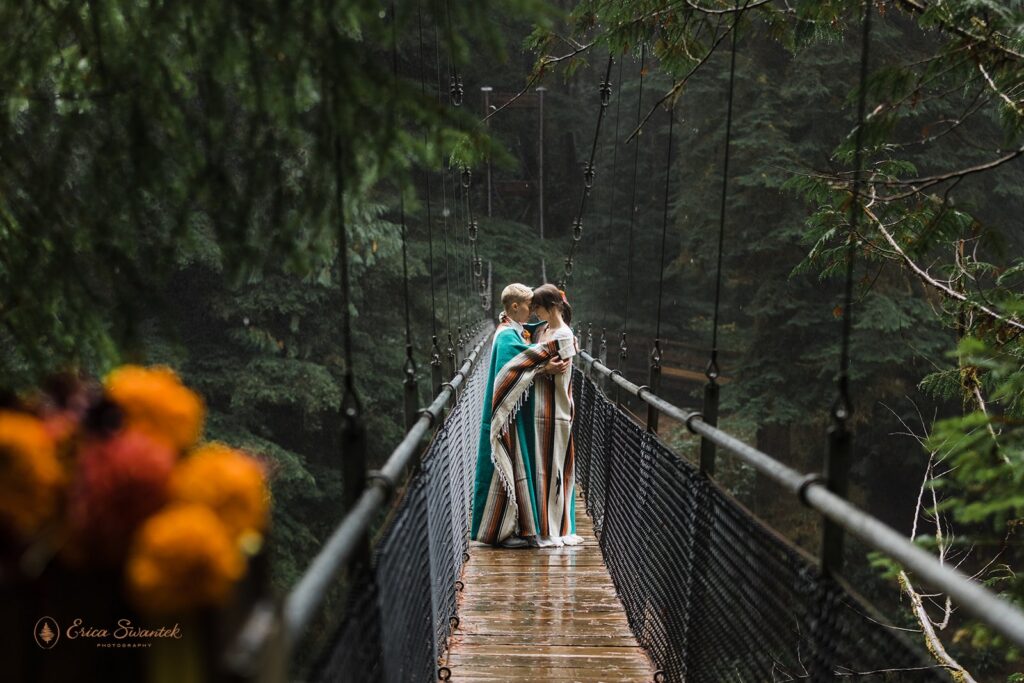 adventurous elopement couple snuggling on a bridge during their pnw waterfall elopement