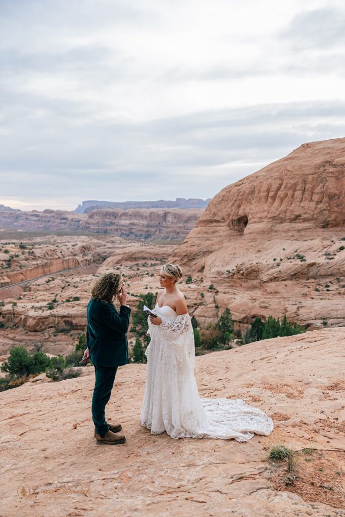 candid moab desert elopement ceremony at corona arch