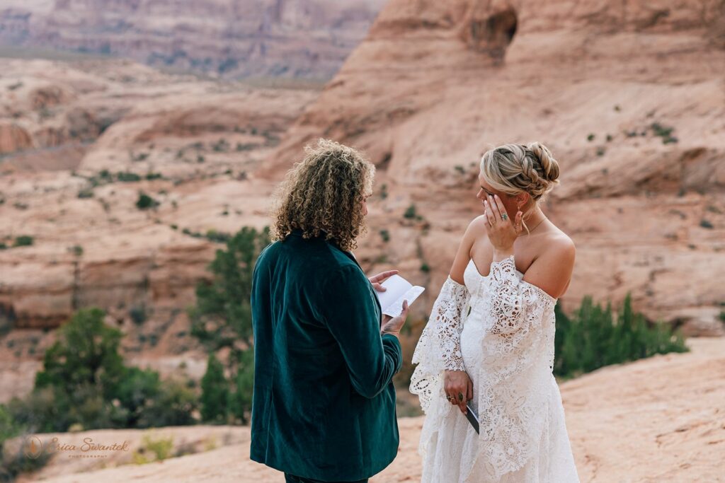 candid moab desert elopement ceremony at corona arch