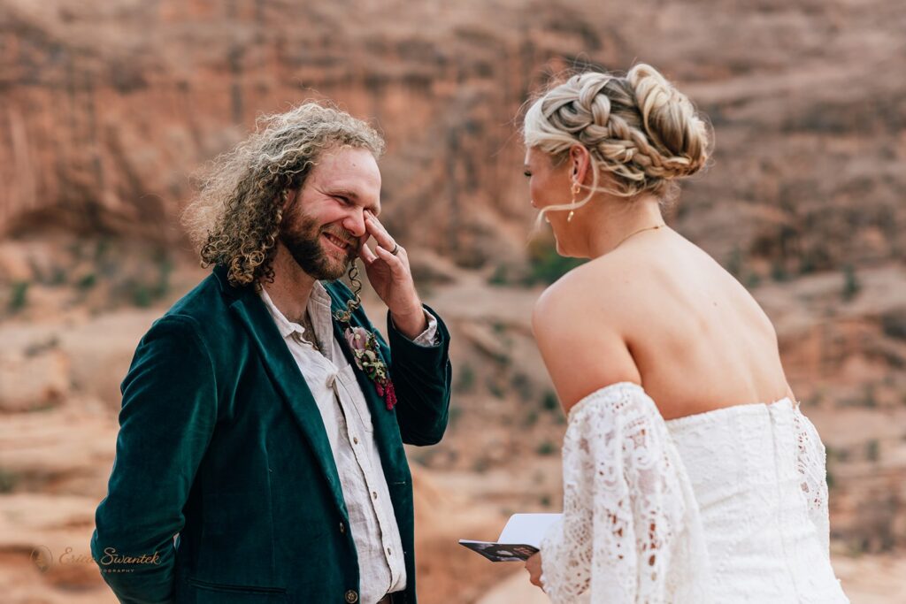 candid moab desert elopement ceremony at corona arch