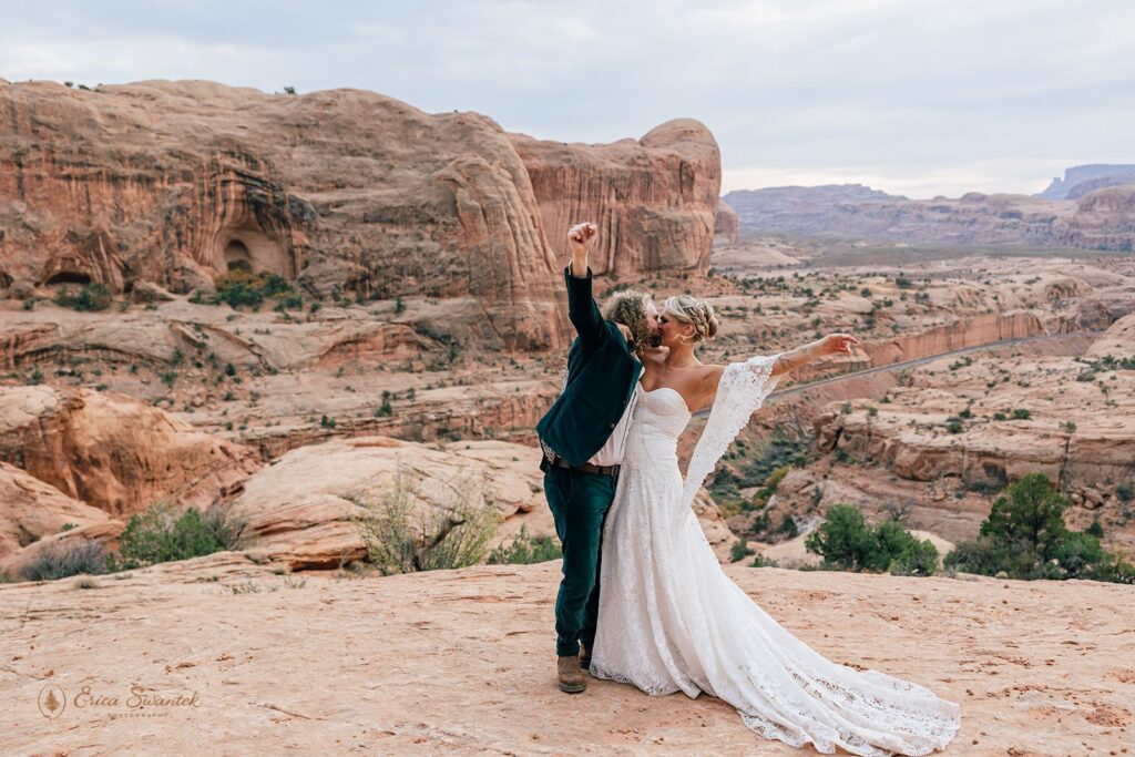 bride and groom kissing and celebrating their elopement in Moab