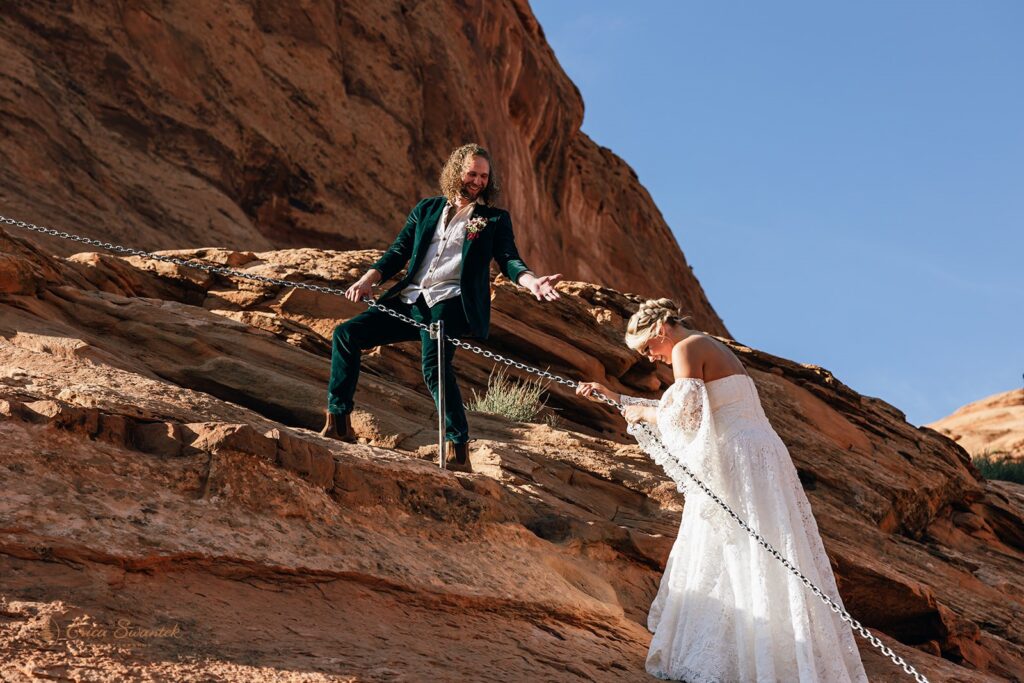 elopement couple hiking the corona arch for their moab adventure elopement