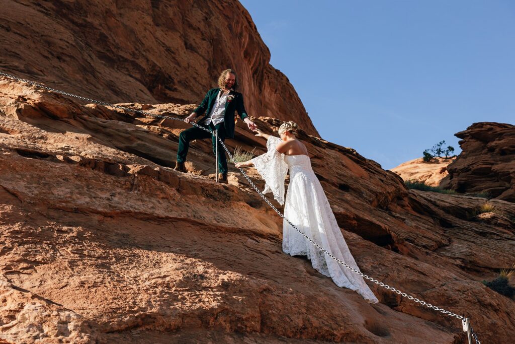 elopement couple hiking the corona arch for their moab adventure elopement