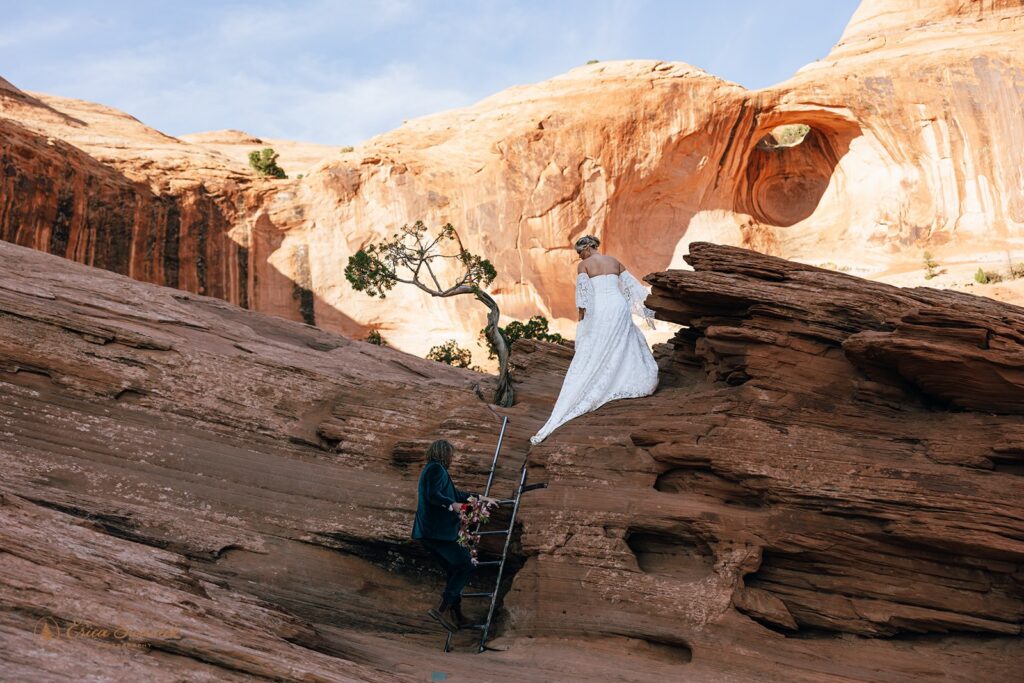 adventurous elopement couple hiking the red rock cliffs in moab during their skydiving wedding day