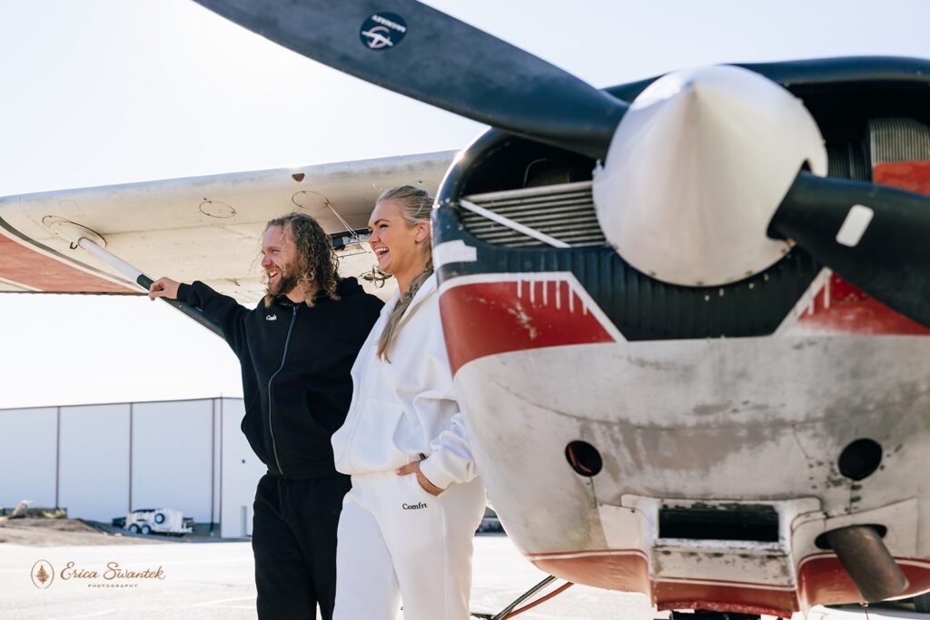elopement couple posing in front of a small plane ahead of their skydiving wedding in moab, utah