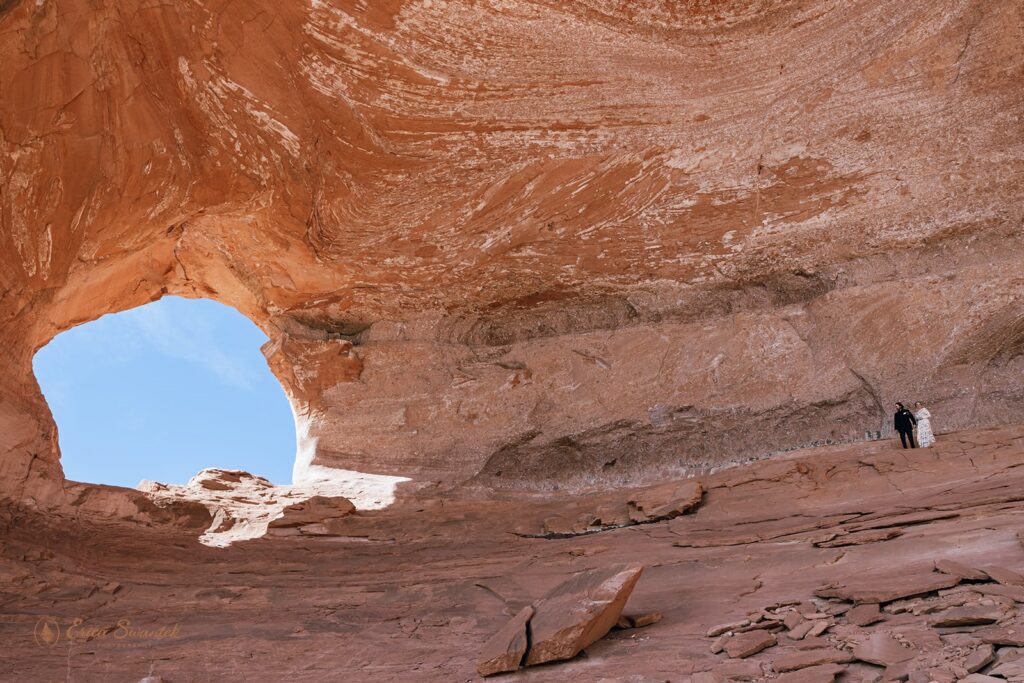 adventure elopement couple hiking up to looking glass arch in moab