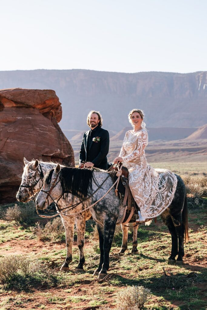 bride and groom horseback riding during their western elopement in moab