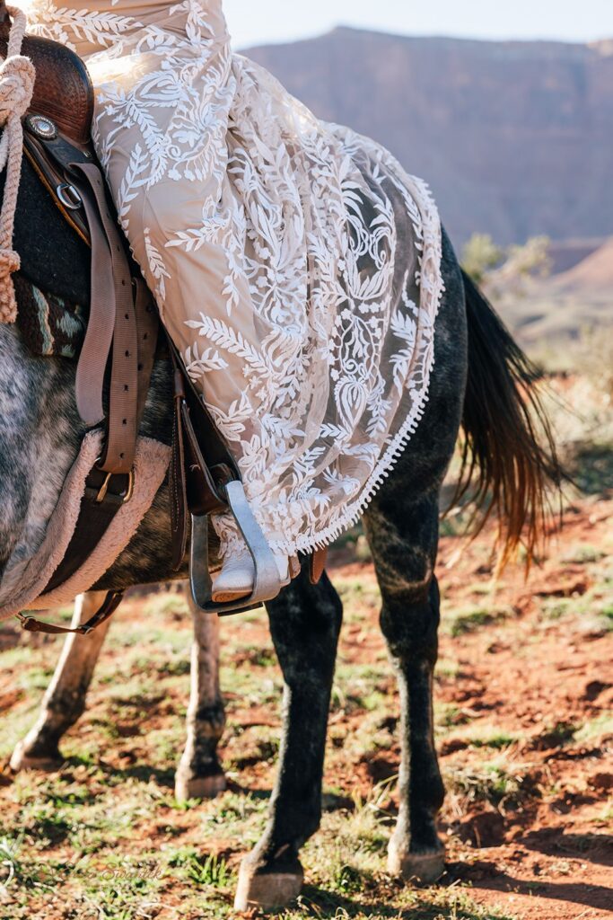 bride horseback riding during western elopement in moab