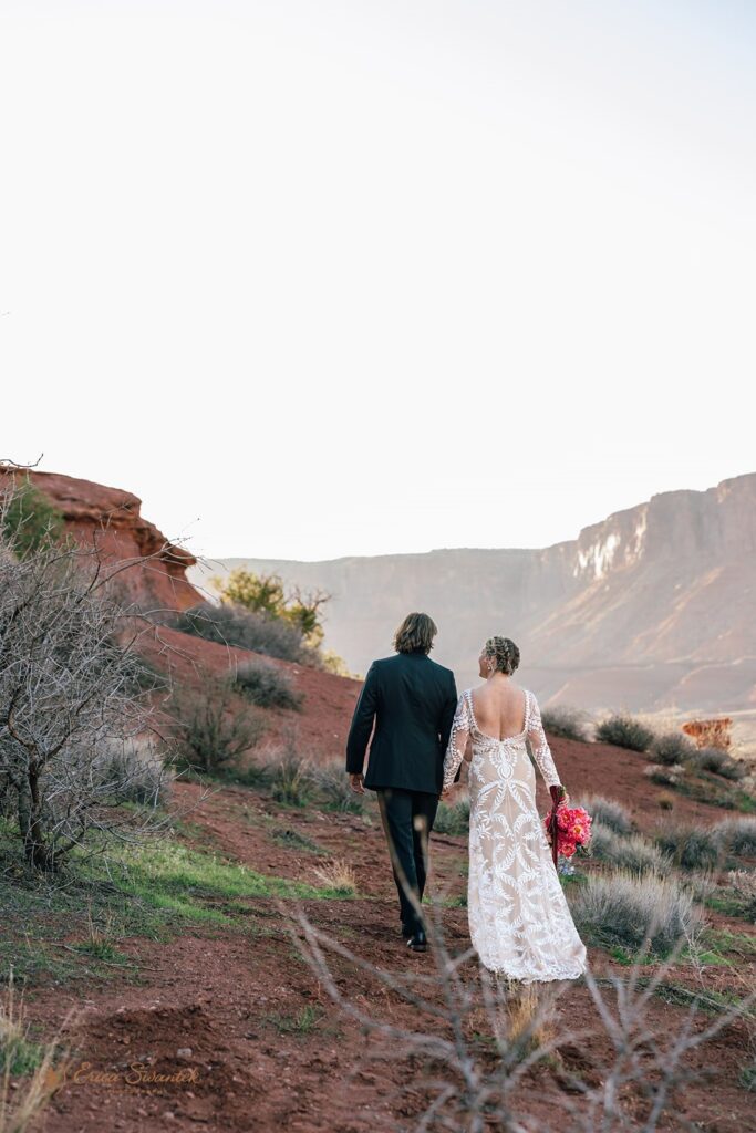 adventurous elopement couple walking around the red desert in moab