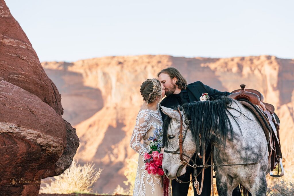 elopement couple posing with their horse during their western elopement in moab