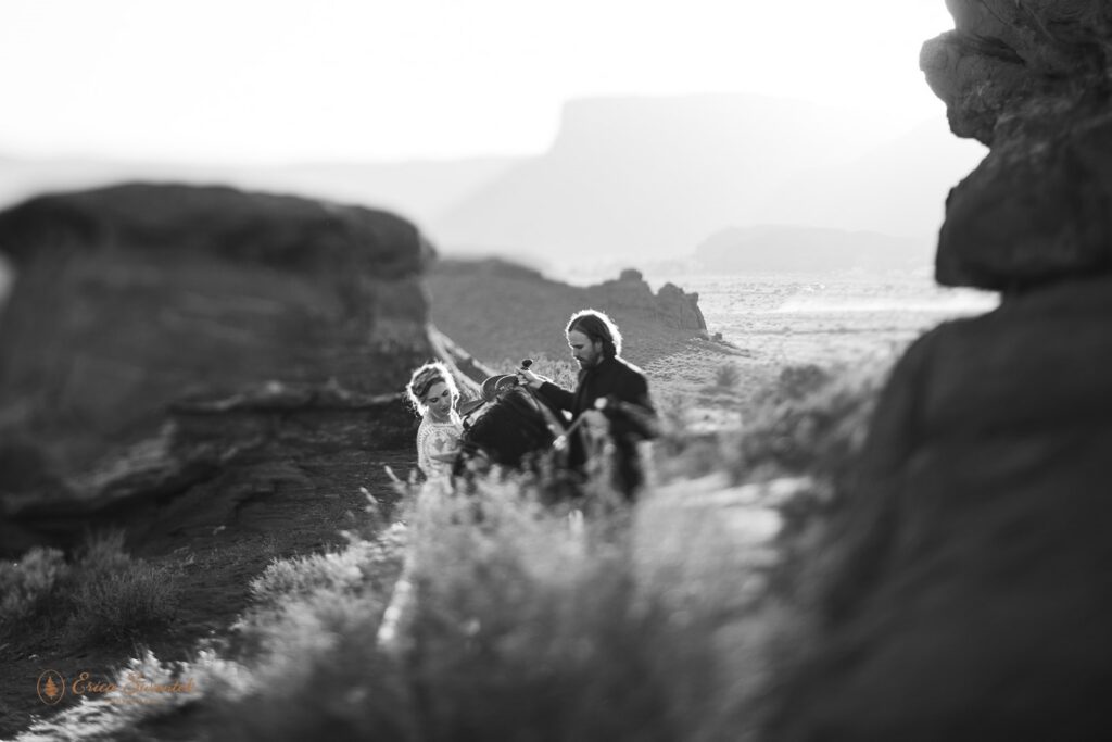 elopement couple posing with a horse during their western horseback riding elopement in moab