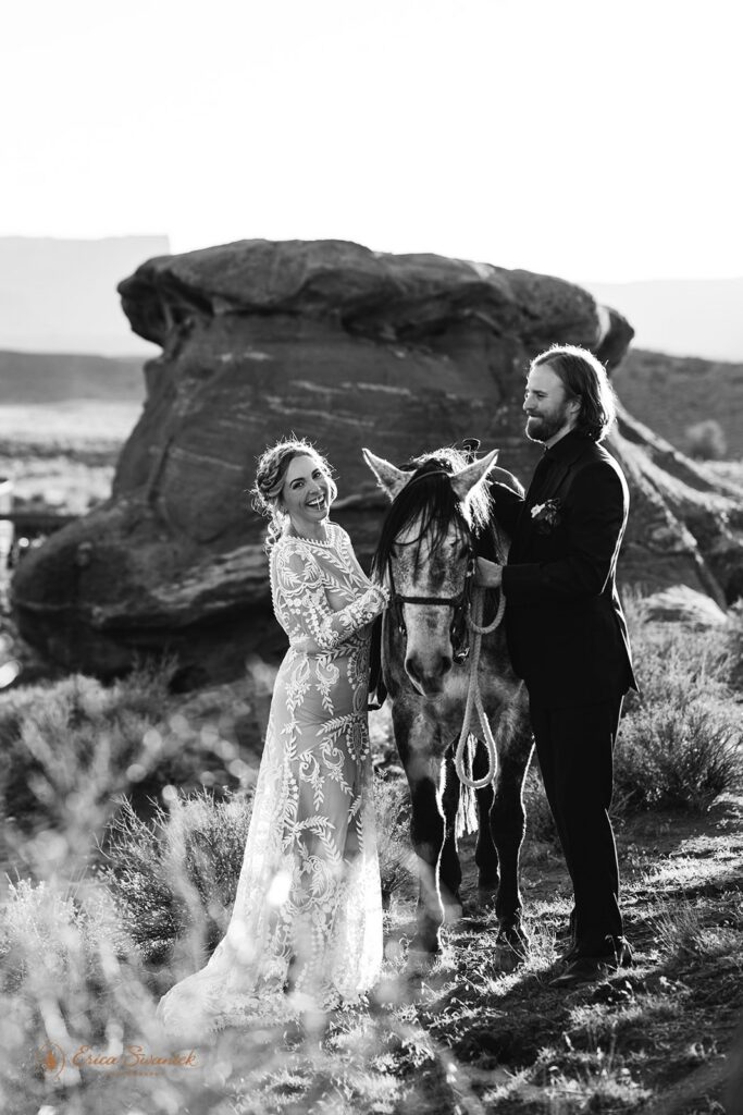 bride and groom posing with their horse during their western elopement in moab