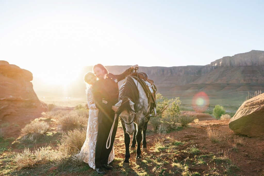 elopement couple posing with their horse during their western elopement in moab