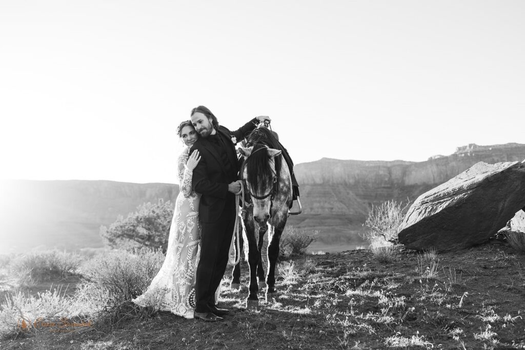 bride and groom posing with their horse during their western elopement in moab