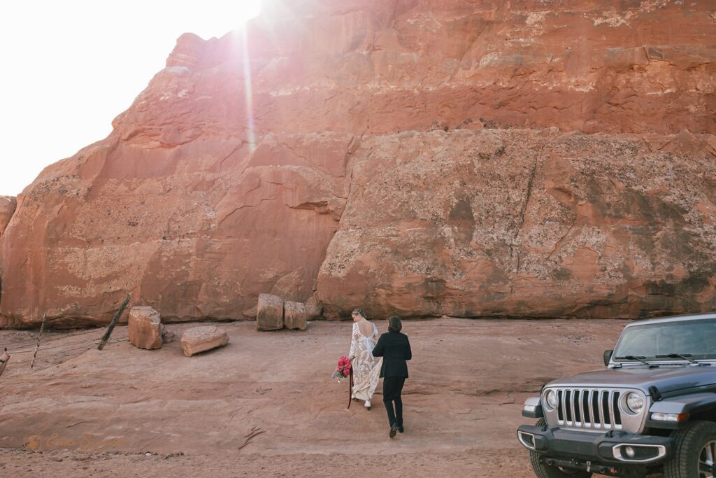 adventure elopement couple hiking up to looking glass arch in moab