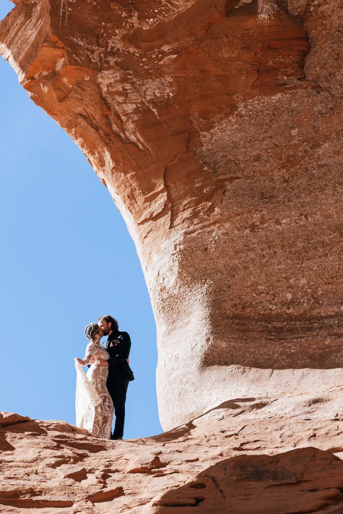 bride and groom at the looking glass arch during their moab elopement
