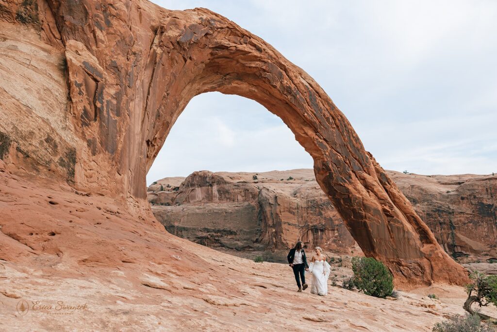 bride and groom at corona arch in moab