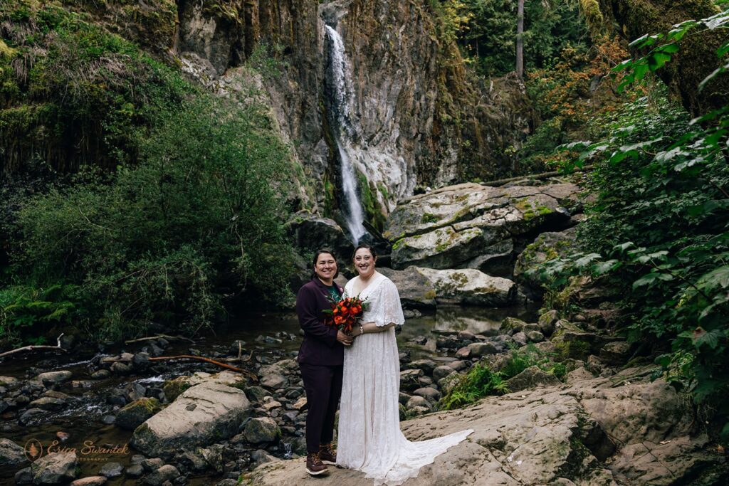 adventurous elopement couple in front of a waterfall during their pnw elopement