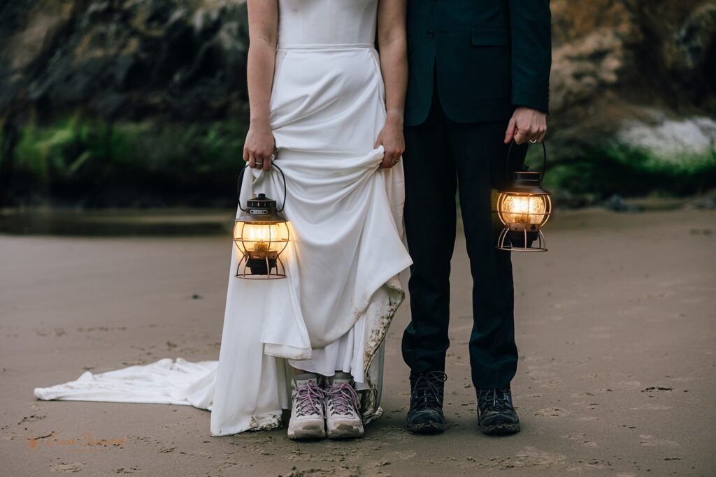 elopement couple holding lanterns and showing off their hiking shoes