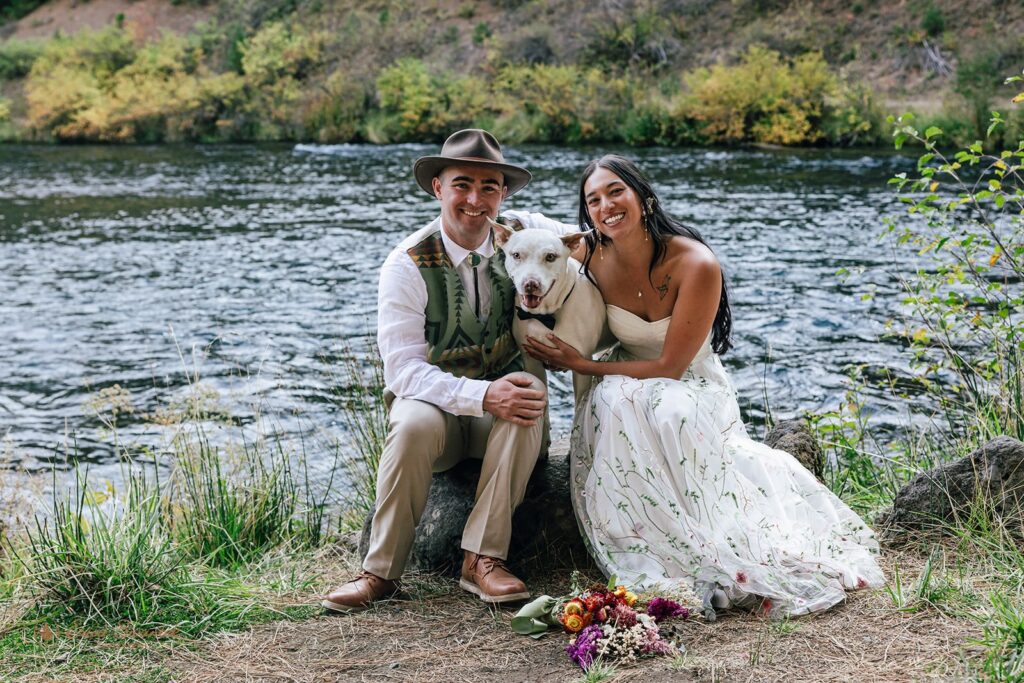 playful elopement couple surrounded by lush forest in front of a river during their pnw elopement