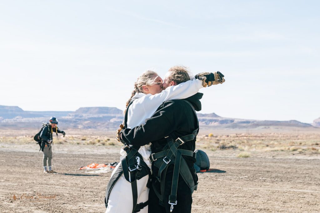 bride and groom kissing after skydiving experience