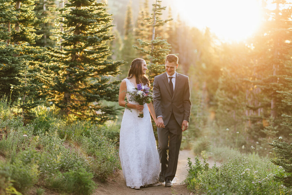 Couple walking through gorgeous sunrise light in their wedding attire at their Mt. Rainier National Park 2 day intimate wedding.