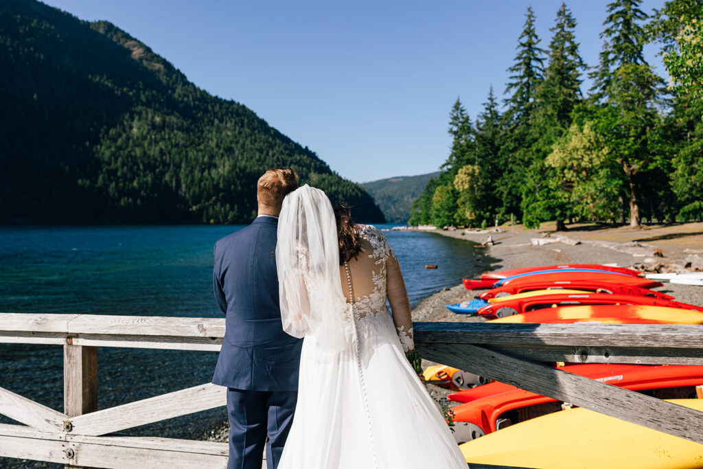 A couple glances out over Lake Crescent in Olympic National Park on their wedding day. 