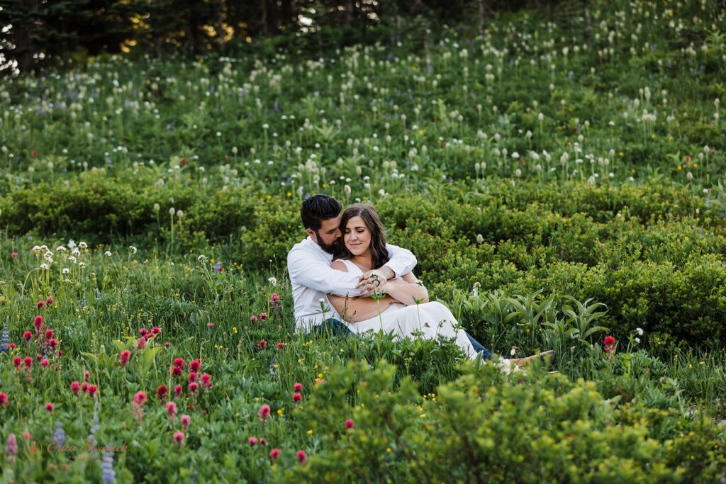 elopement couple snuggling in a wildflower field