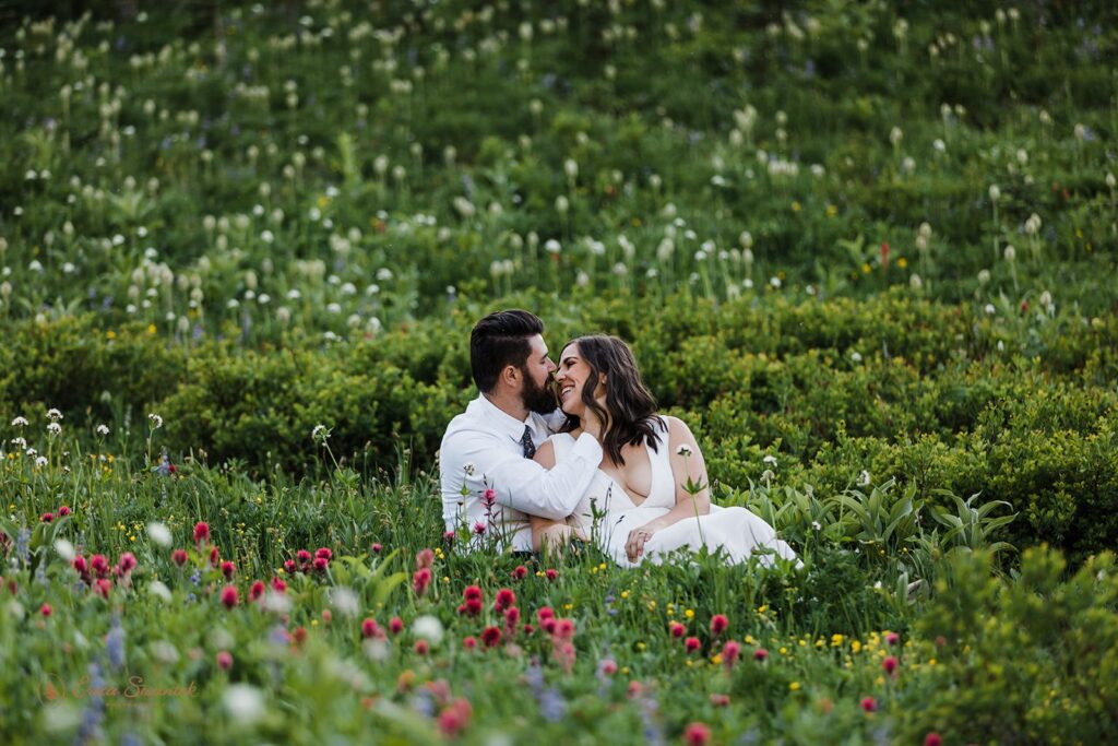 elopement couple snuggling in a wildflower field