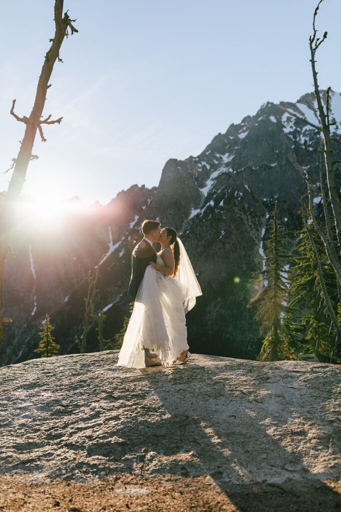 elopement couple snuggling with epic mountain views in the backdrop in the pacific north west