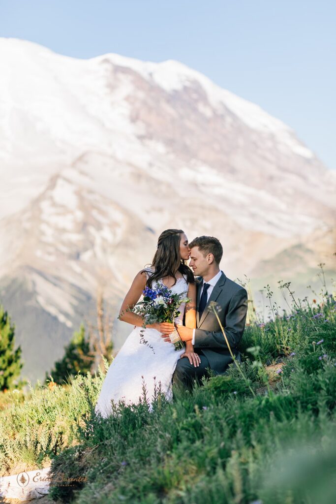 elopement couple snuggling with epic mountain views in the backdrop in the pacific north west