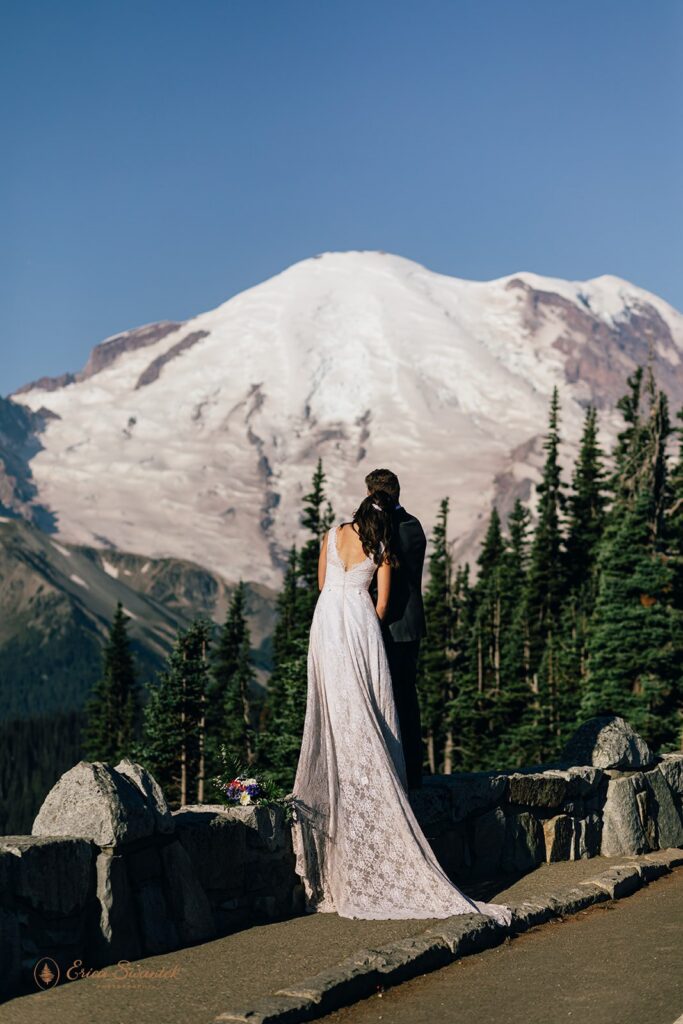 elopement couple snuggling with epic mountain views in the backdrop in the pacific north west