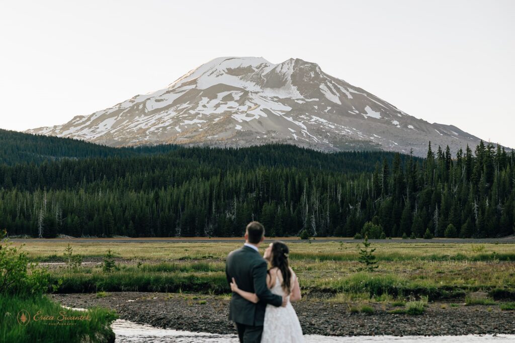 elopement couple snuggling with epic mountain views in the backdrop in the pacific north west
