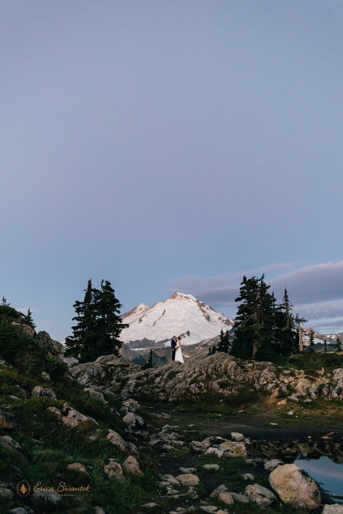 elopement couple snuggling with epic mountain views in the backdrop in the pacific north west